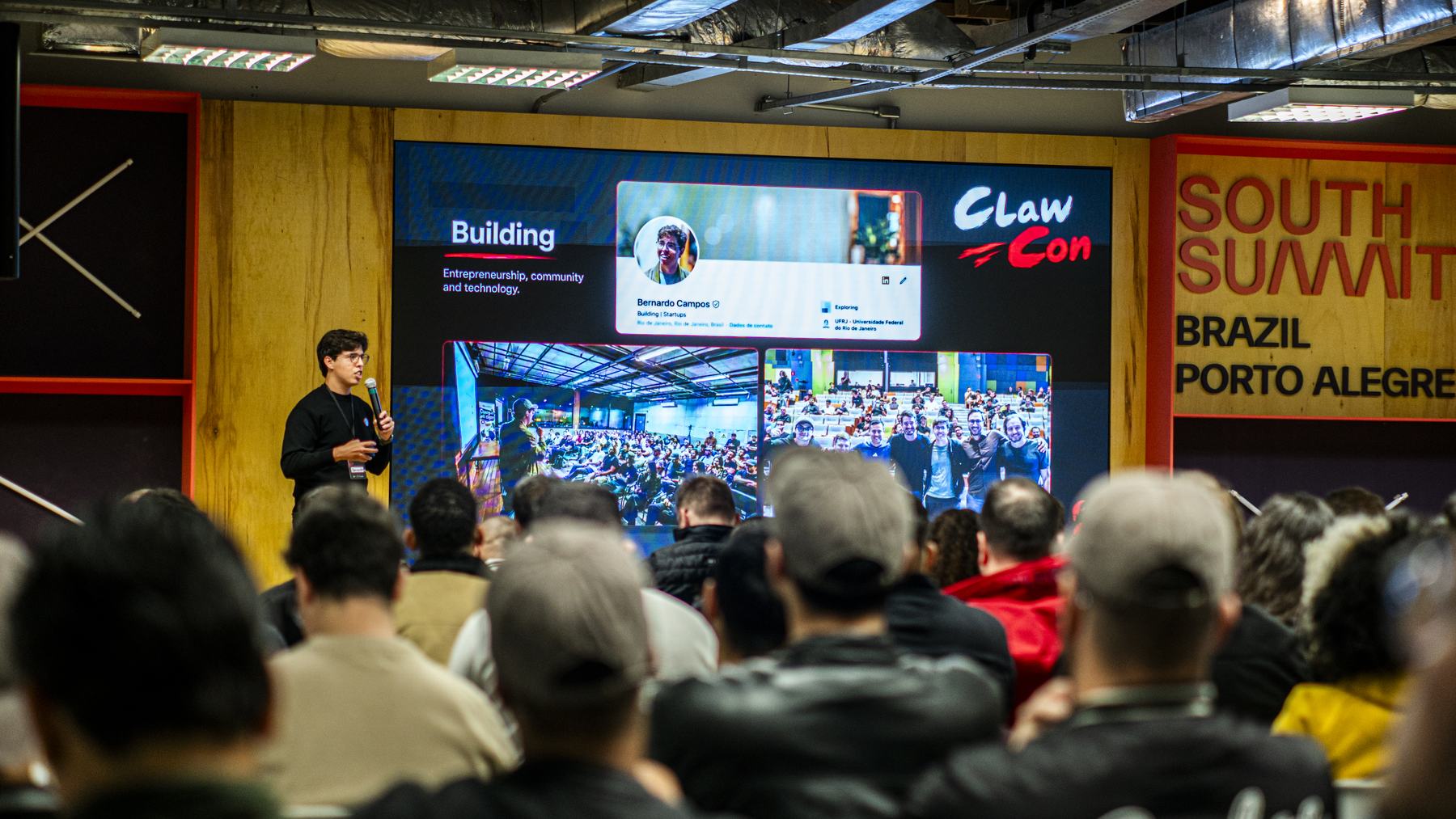 Auditório cheio na ClawCon Porto Alegre, com o telão do South Summit ao fundo
